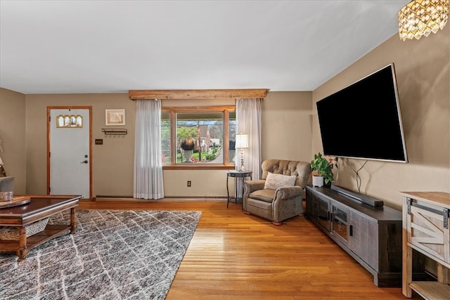 living room featuring a notable chandelier and light hardwood / wood-style flooring