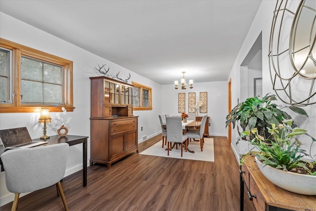 dining area featuring dark wood-type flooring and a notable chandelier