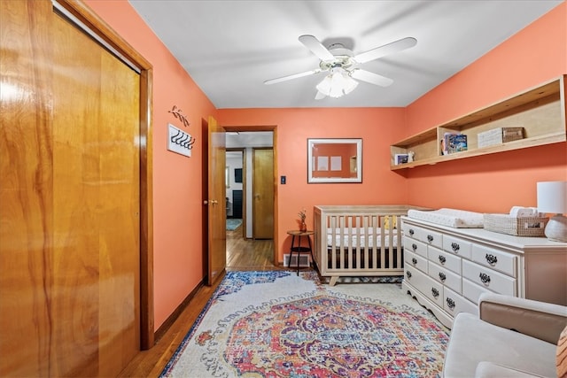 bedroom featuring a closet, ceiling fan, light hardwood / wood-style flooring, and a nursery area