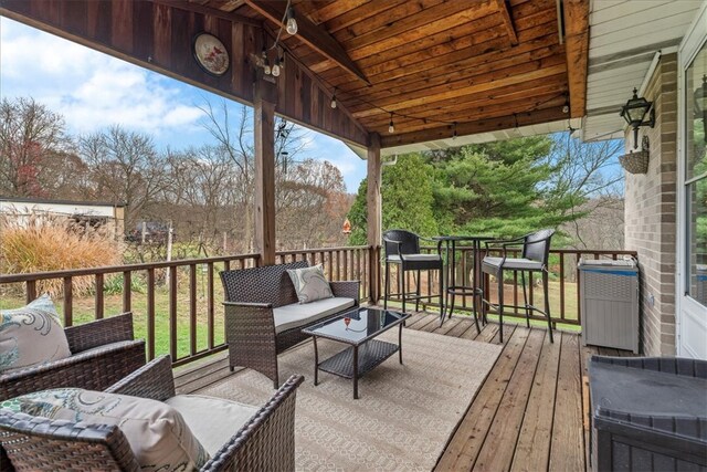 wooden terrace with an outdoor living space