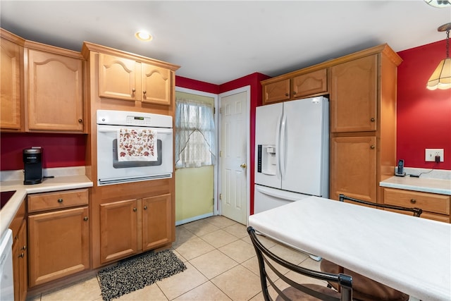 kitchen featuring white appliances, decorative light fixtures, and light tile patterned flooring