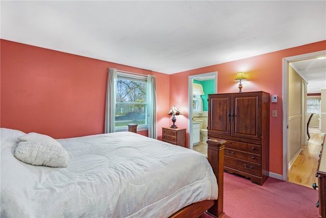 bedroom featuring light carpet and ensuite bath