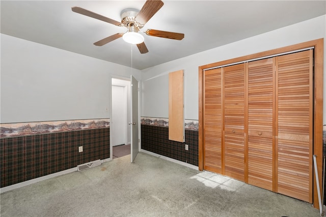 unfurnished bedroom featuring ceiling fan, a closet, and carpet floors