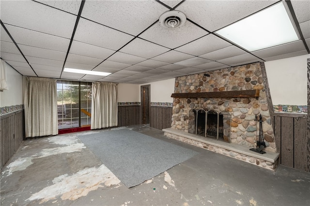 unfurnished living room featuring a paneled ceiling and concrete floors