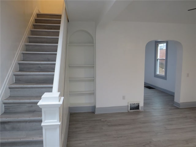 stairs featuring hardwood / wood-style floors