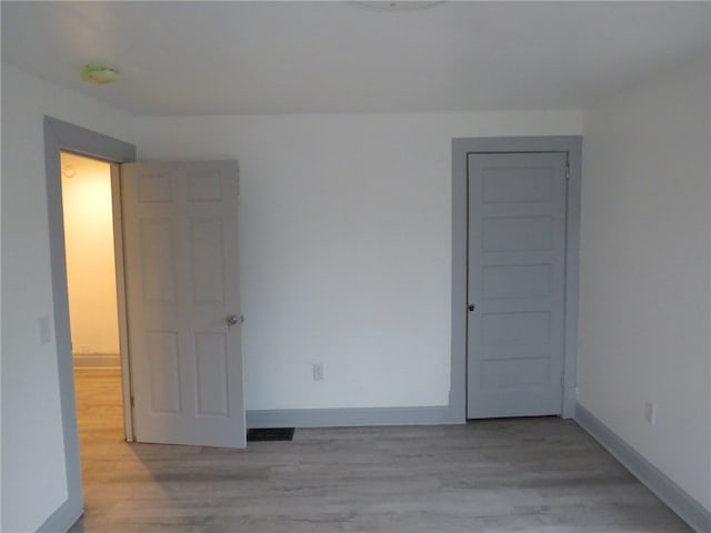 unfurnished room with light wood-type flooring