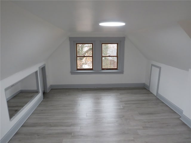 bonus room with light hardwood / wood-style floors and vaulted ceiling