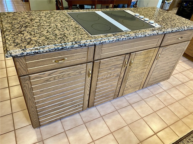 kitchen featuring black electric stovetop, stone countertops, and light tile patterned floors