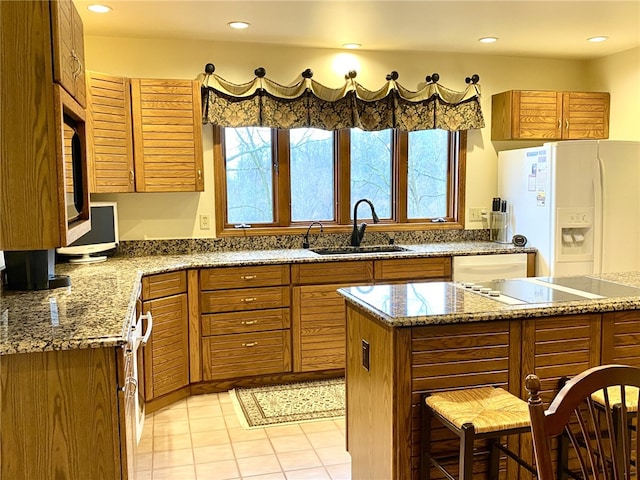 kitchen with light stone countertops, sink, a center island, and stainless steel appliances