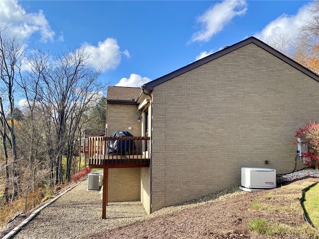 view of side of property with cooling unit and a deck