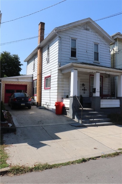 front facade featuring covered porch and a garage