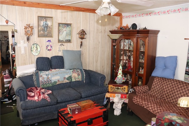 living room featuring crown molding, ceiling fan, and wood walls