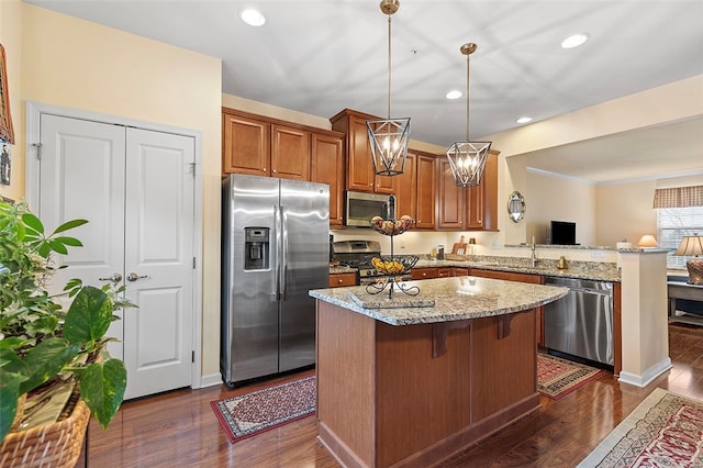 kitchen with kitchen peninsula, pendant lighting, stainless steel appliances, and dark hardwood / wood-style floors