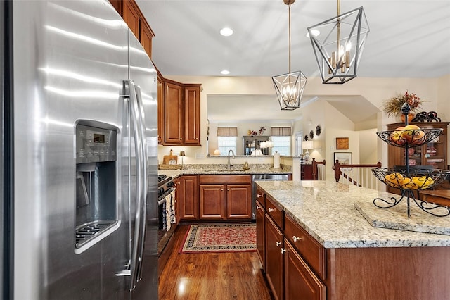 kitchen with sink, dark hardwood / wood-style floors, a chandelier, decorative light fixtures, and appliances with stainless steel finishes