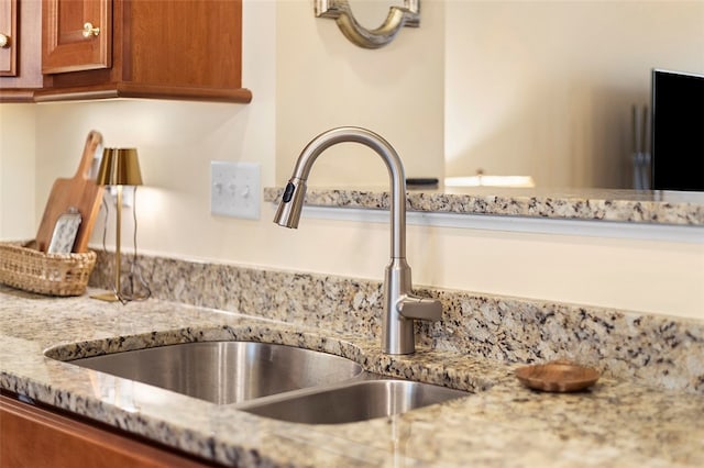 interior details featuring light stone counters and sink