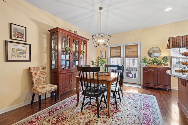 dining space featuring dark hardwood / wood-style flooring and a chandelier