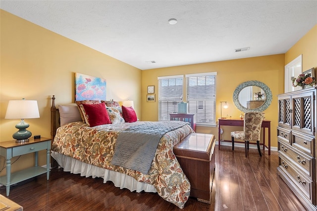 bedroom with a textured ceiling and dark wood-type flooring