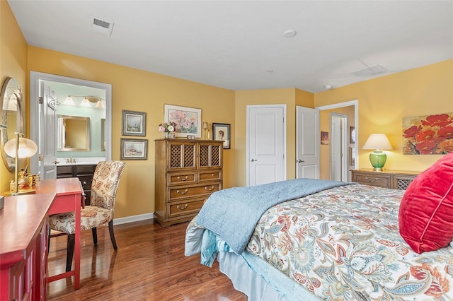 bedroom featuring dark hardwood / wood-style flooring and connected bathroom