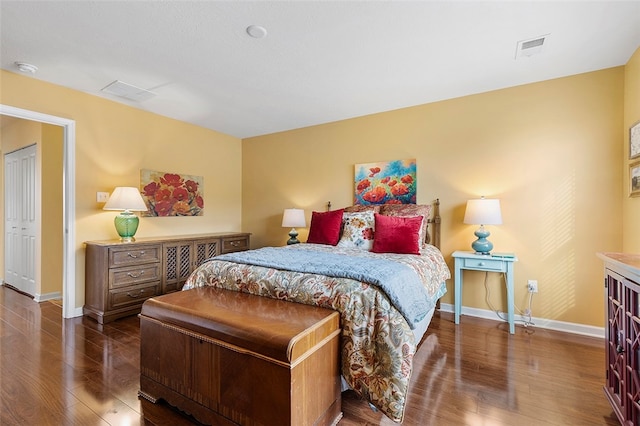 bedroom with dark hardwood / wood-style flooring and a closet