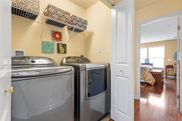 washroom featuring dark hardwood / wood-style flooring and washing machine and clothes dryer