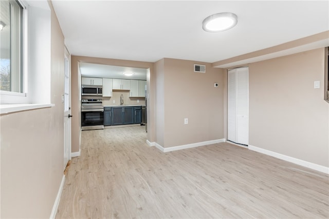 empty room with sink and light wood-type flooring