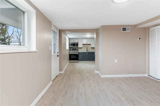 hall with sink and light hardwood / wood-style flooring