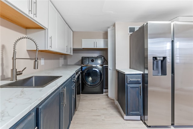 kitchen with white cabinets, washer / dryer, blue cabinetry, and stainless steel fridge with ice dispenser