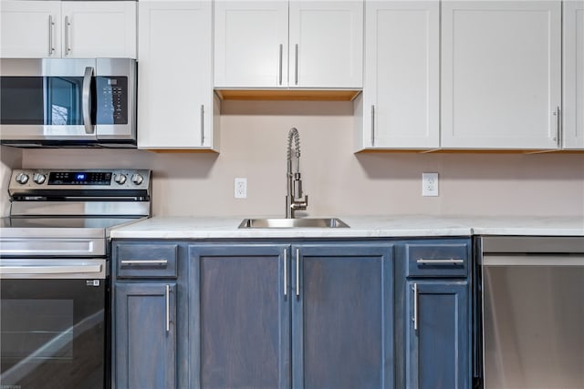 kitchen with sink, white cabinetry, stainless steel appliances, and blue cabinets