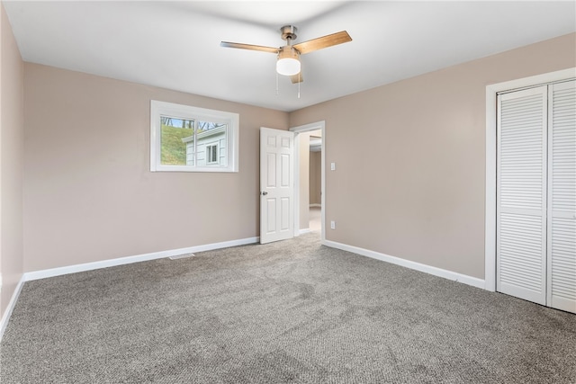 unfurnished bedroom featuring carpet floors, a closet, and ceiling fan