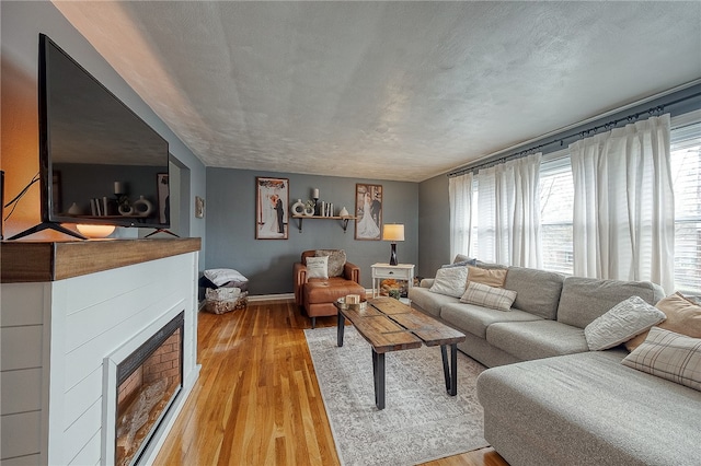 living room with a textured ceiling and light wood-type flooring