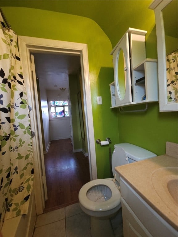 bathroom with hardwood / wood-style floors, vanity, toilet, and walk in shower