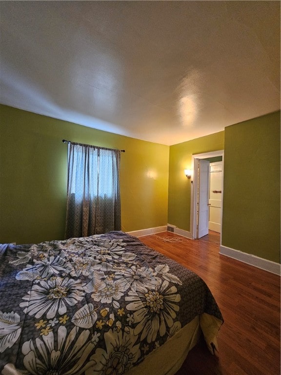 bedroom with wood-type flooring and connected bathroom