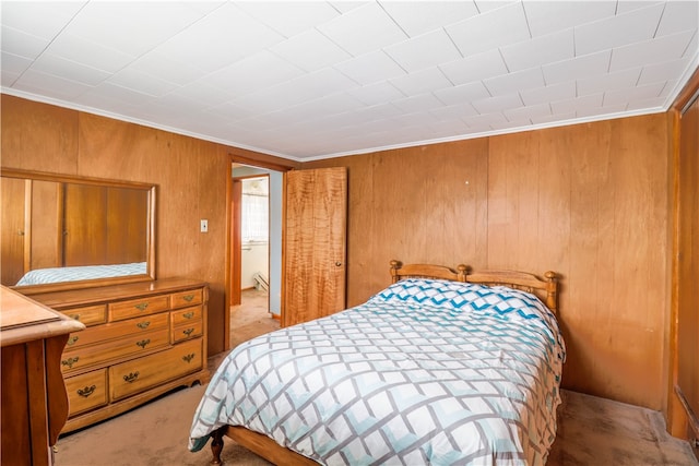 carpeted bedroom with wood walls and crown molding