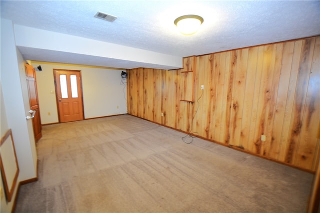 empty room with light carpet and wooden walls