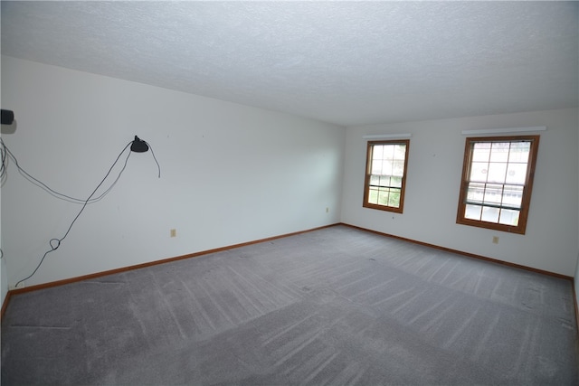 spare room featuring carpet floors and a textured ceiling