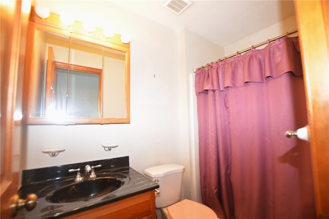 bathroom with vanity, toilet, and walk in shower