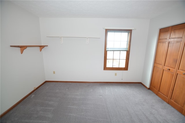 unfurnished bedroom with a textured ceiling, light carpet, and a closet