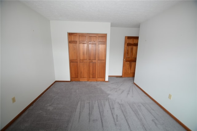 unfurnished bedroom with light carpet, a closet, and a textured ceiling