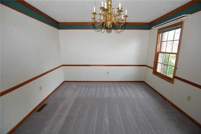 carpeted empty room featuring a textured ceiling, crown molding, and a notable chandelier