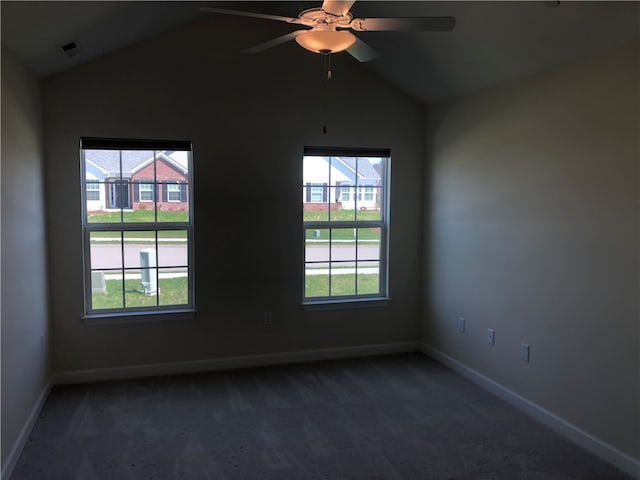 carpeted empty room featuring ceiling fan, lofted ceiling, and a wealth of natural light