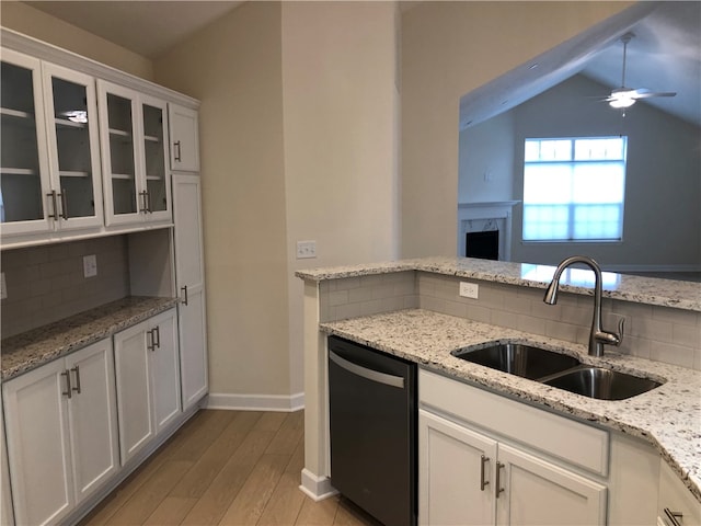 kitchen featuring white cabinets, vaulted ceiling, ceiling fan, sink, and dishwasher