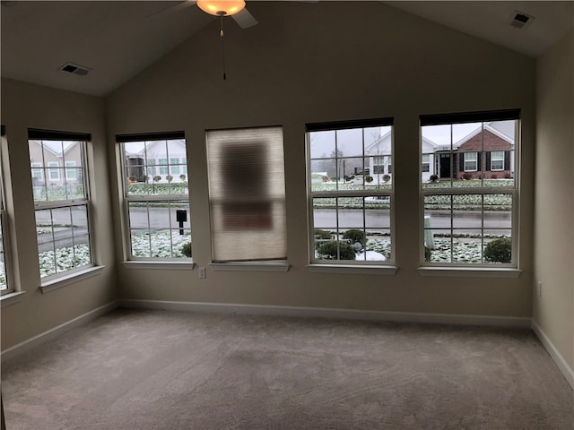 spare room with carpet flooring, plenty of natural light, and vaulted ceiling