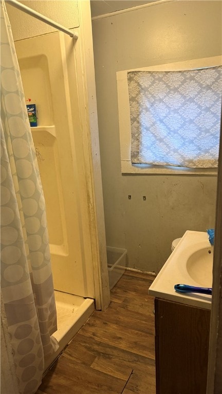 bathroom with hardwood / wood-style floors, vanity, and walk in shower