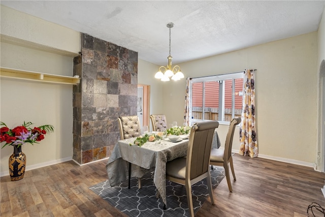 dining area featuring dark hardwood / wood-style flooring, a chandelier, and a textured ceiling