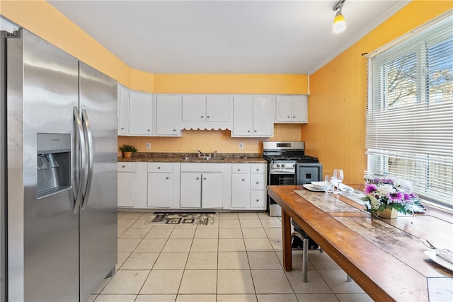 kitchen featuring plenty of natural light, white cabinetry, stainless steel appliances, and ornamental molding