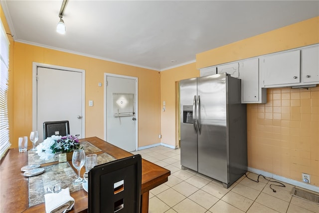 kitchen featuring white cabinetry, stainless steel fridge with ice dispenser, light tile patterned floors, and ornamental molding