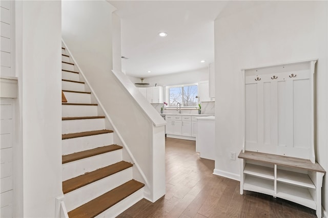 stairway featuring wood-type flooring and sink