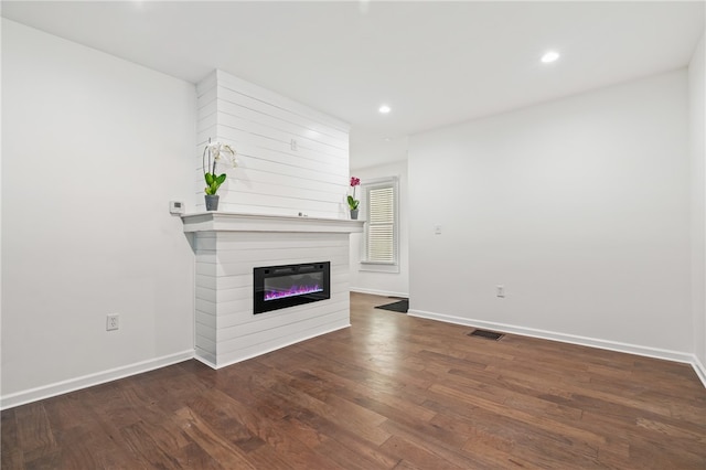 unfurnished living room with a fireplace and dark hardwood / wood-style flooring