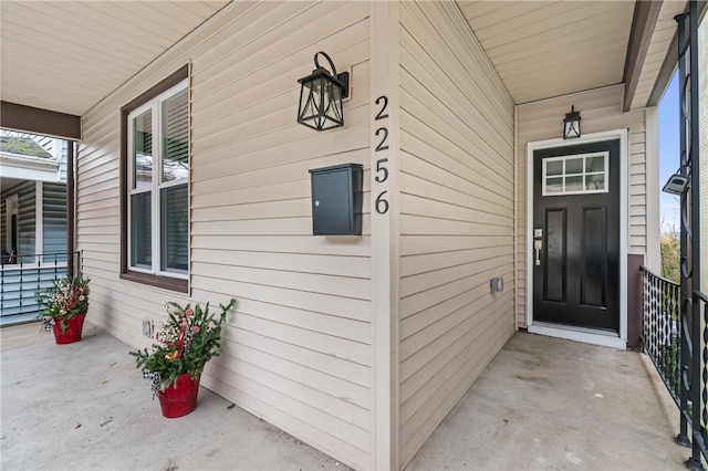 view of exterior entry featuring covered porch