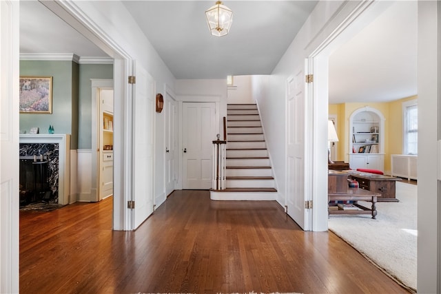 foyer featuring a premium fireplace, hardwood / wood-style floors, ornamental molding, and radiator heating unit